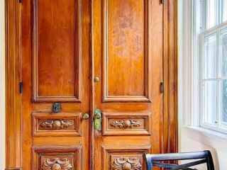 Reclaimed hand-carved, Spanish doors used for front entry coat closet