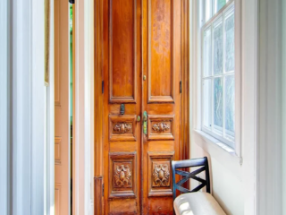 Reclaimed hand-carved, Spanish doors used for front entry coat closet
